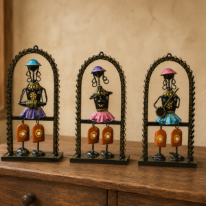 Set of three handcrafted Rajasthani-style metal figurine wall decor panels with colorful traditional attire, displayed on a table and mounted on a wall.