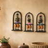 Set of three handcrafted Rajasthani-style metal figurine wall decor panels with colorful traditional attire, displayed on a table and mounted on a wall.