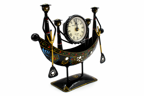 Decorative handcrafted metal boat-shaped table clock with colorful traditional Indian artwork, displayed on a wooden living room table.