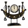 Decorative handcrafted metal boat-shaped table clock with colorful traditional Indian artwork, displayed on a wooden living room table.