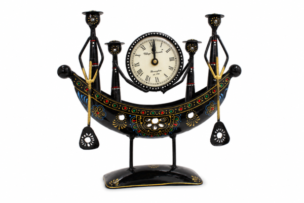 Decorative handcrafted metal boat-shaped table clock with colorful traditional Indian artwork, displayed on a wooden living room table.