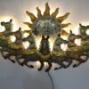 Decorative multicolor metal wall art featuring seven running horses with a large sun design, measuring 46 × 3 × 26 inches.