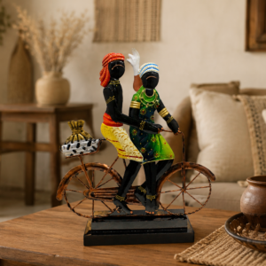 Handcrafted Rajasthani couple riding a bicycle, featuring colorful traditional attire and detailed metalwork on a decorative black base.